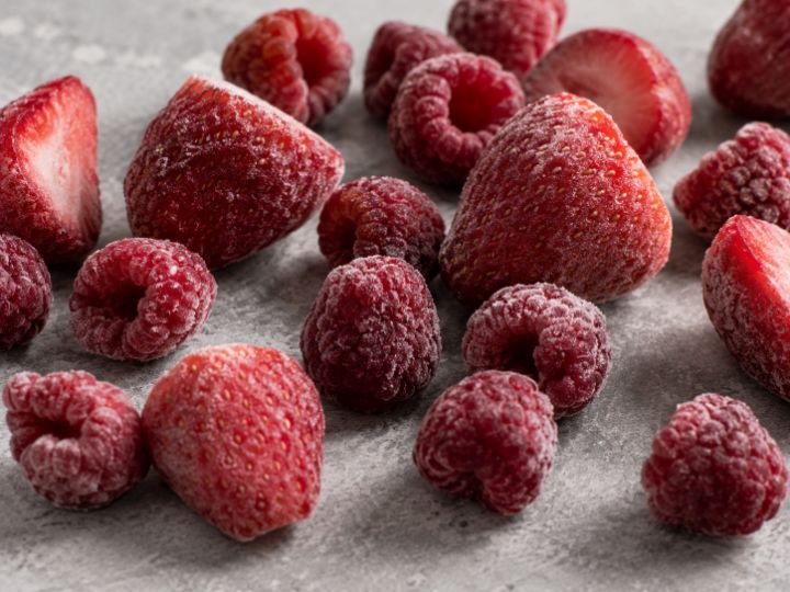 Fresas y frambuesas congeladas individualmente, cubiertas de escarcha.